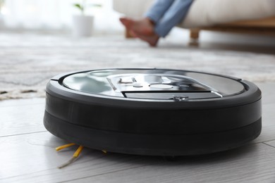 Photo of Robotic vacuum cleaner on floor indoors, selective focus