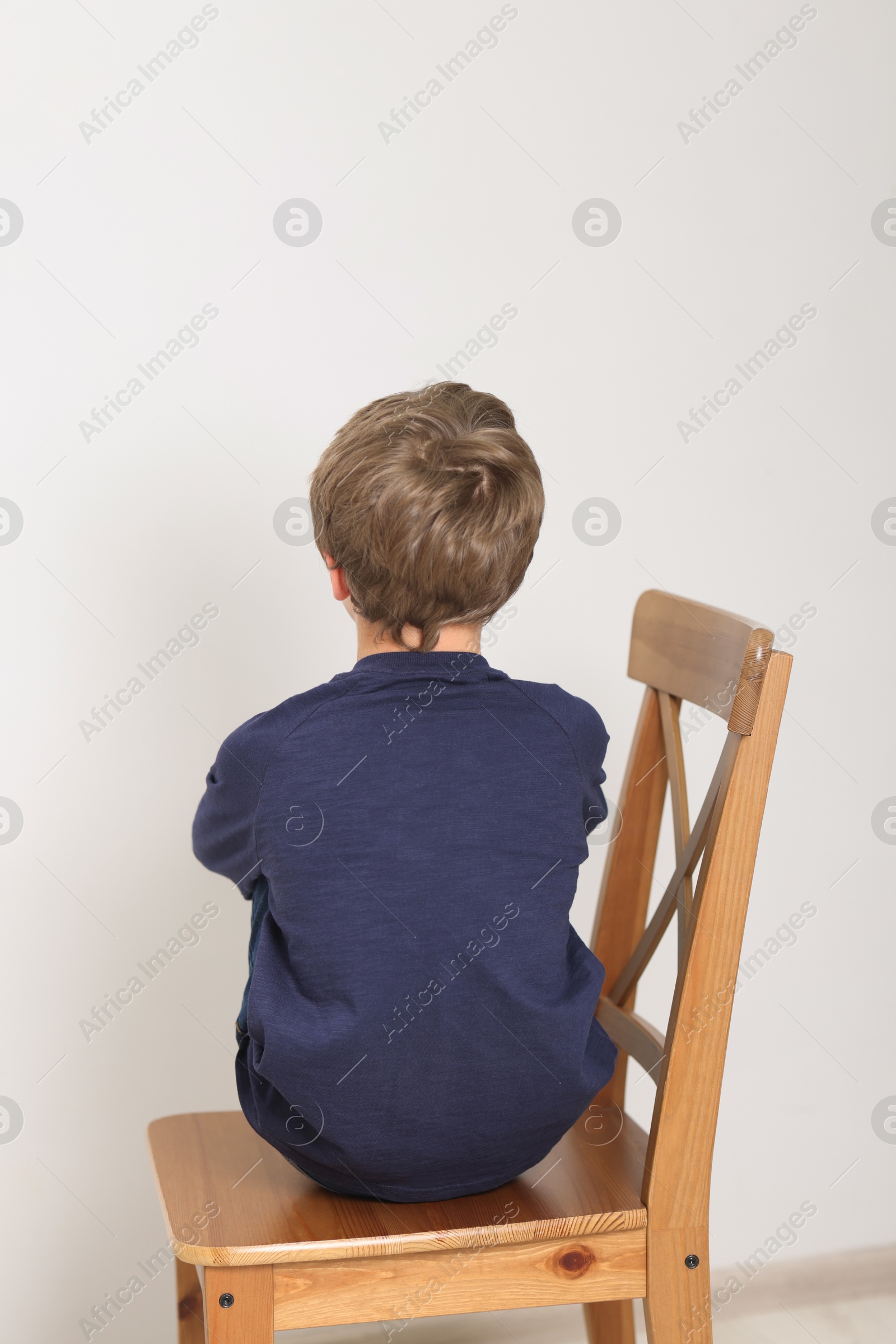 Photo of Autism concept. Lonely little boy on chair at home, back view