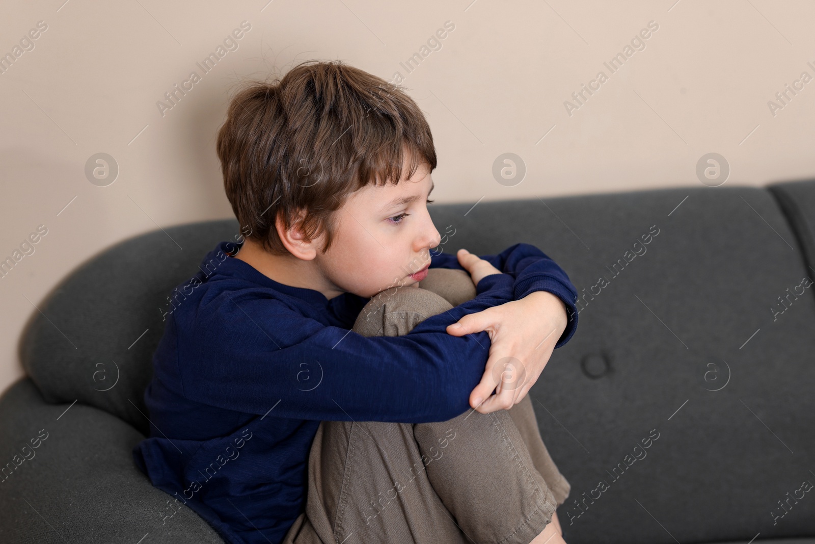 Photo of Autism concept. Lonely little boy on sofa at home