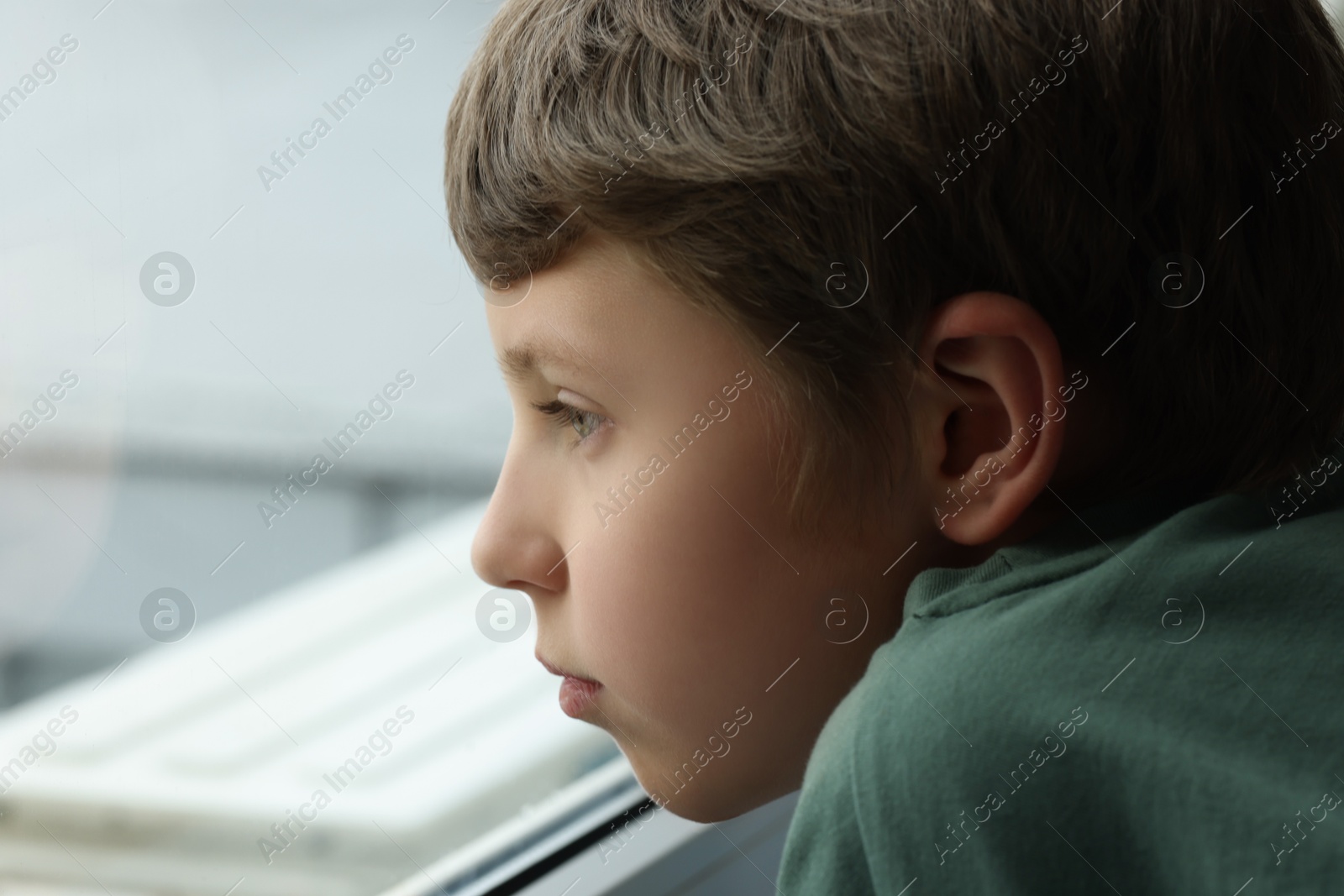 Photo of Autism concept. Lonely little boy near window at home, space for text