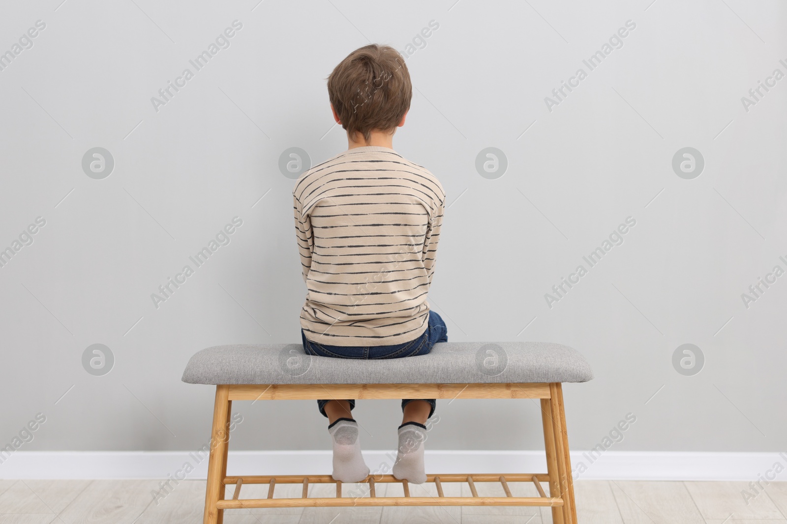 Photo of Autism concept. Lonely little boy on bench at home, back view