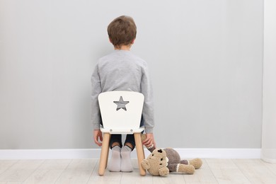 Photo of Autism concept. Lonely little boy with teddy bear at home