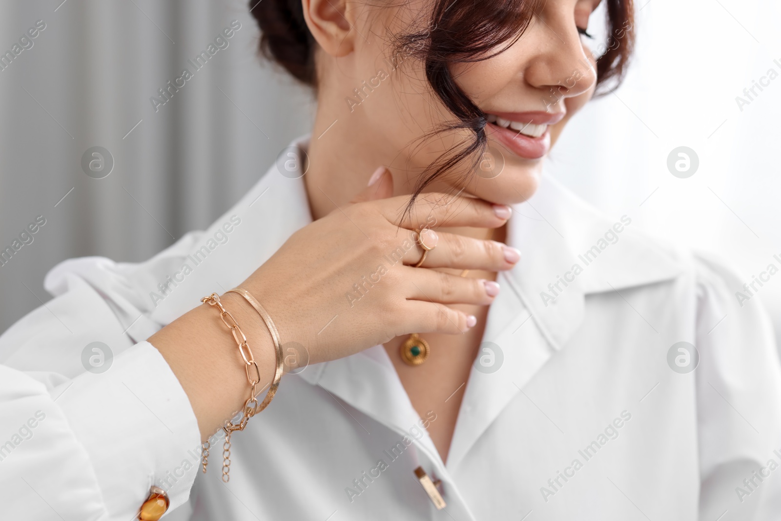 Photo of Young woman wearing elegant jewelry indoors, closeup