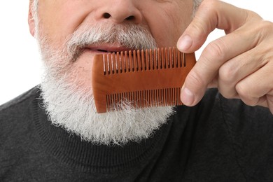 Photo of Senior man combing beard on white background, closeup