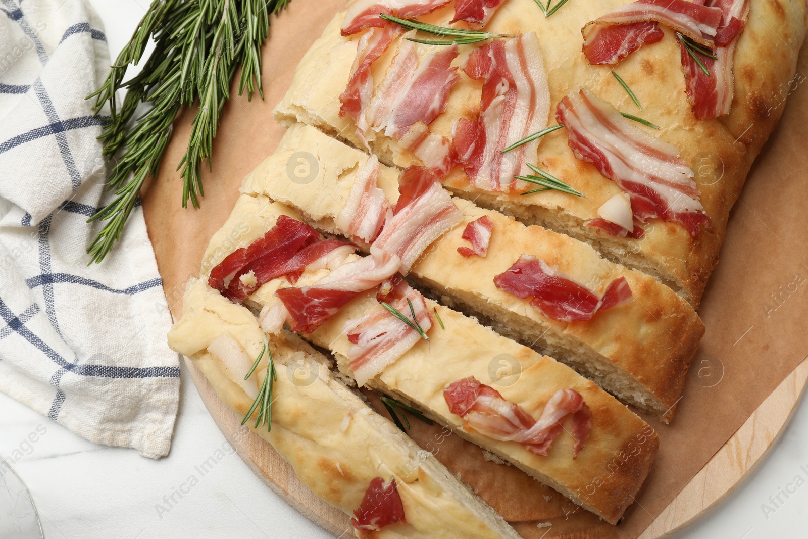 Photo of Slices of delicious focaccia bread with bacon and rosemary on white table, top view