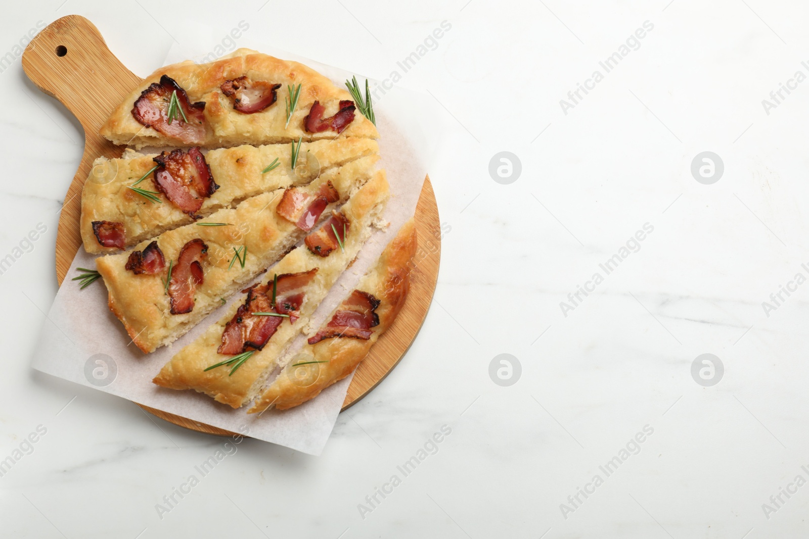 Photo of Slices of delicious focaccia bread with bacon and rosemary on white marble table, top view. Space for text