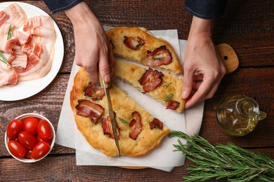 Photo of Woman cutting delicious focaccia bread at wooden table, top view