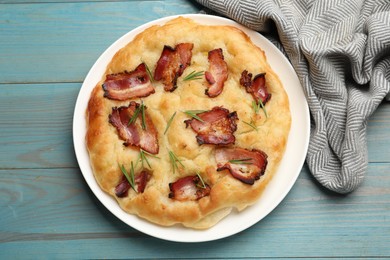 Photo of Delicious focaccia bread with bacon and rosemary on light blue wooden table, top view