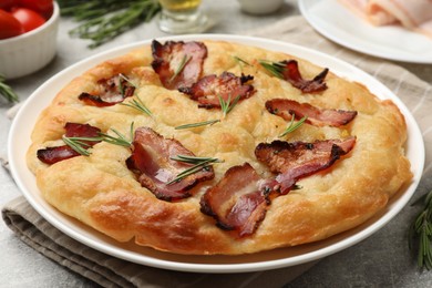 Photo of Delicious focaccia bread with bacon and rosemary on table, closeup