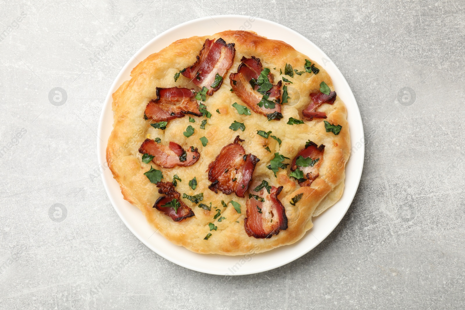 Photo of Delicious focaccia bread with bacon and parsley on light grey table, top view