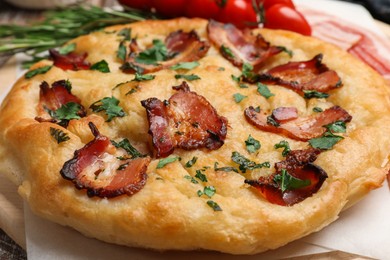 Photo of Delicious focaccia bread with bacon and parsley on table, closeup