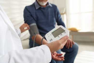 Photo of Doctor measuring patient's blood pressure in hospital, closeup