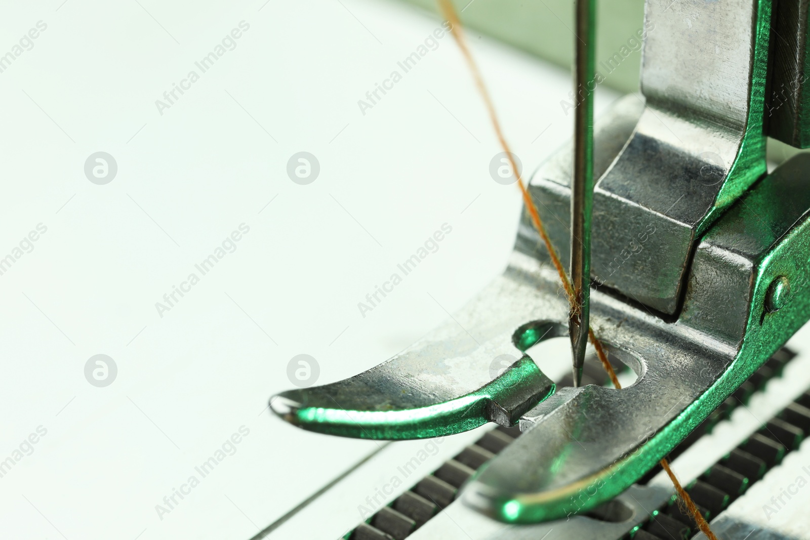 Photo of Sewing machine with thread on white background, macro view. Space for text