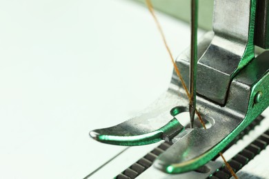 Photo of Sewing machine with thread on white background, macro view. Space for text