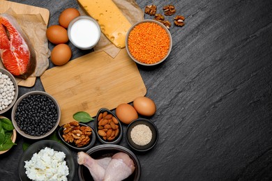 Photo of Different fresh products rich in estrogen and wooden board on grey textured table, flat lay. Space for text