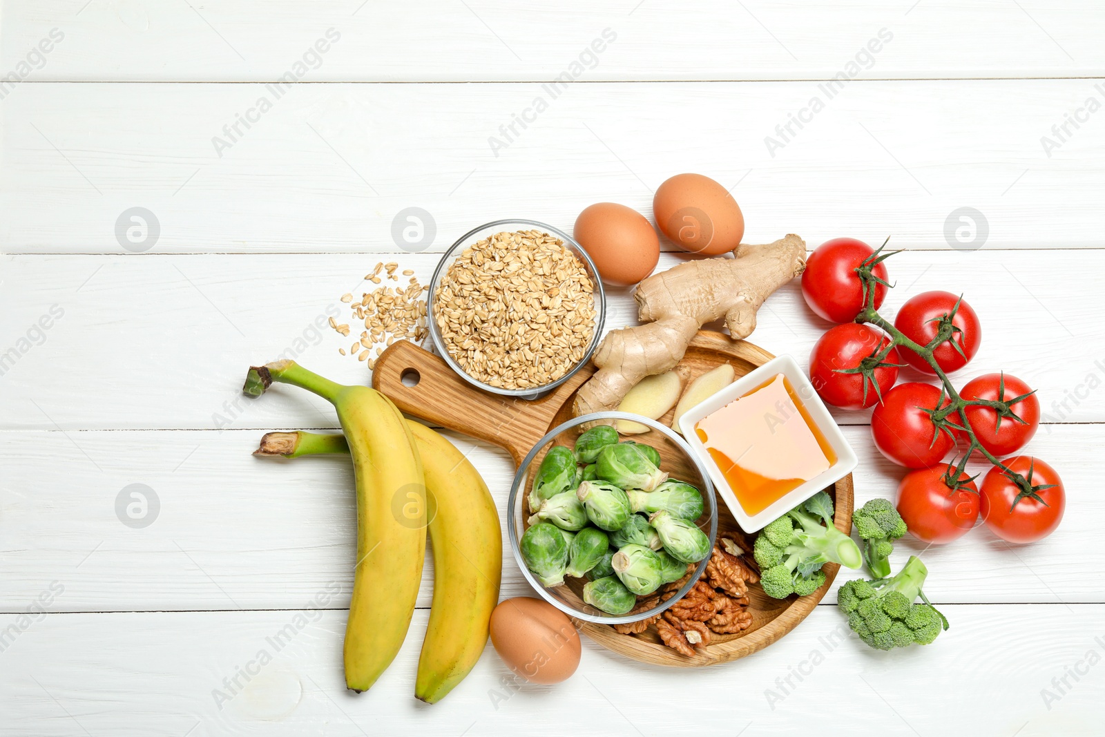 Photo of Different fresh products rich in melatonin on white wooden table, flat lay