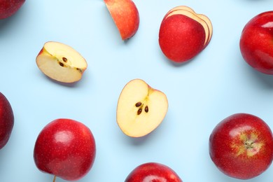 Fresh ripe red apples on light blue background, flat lay