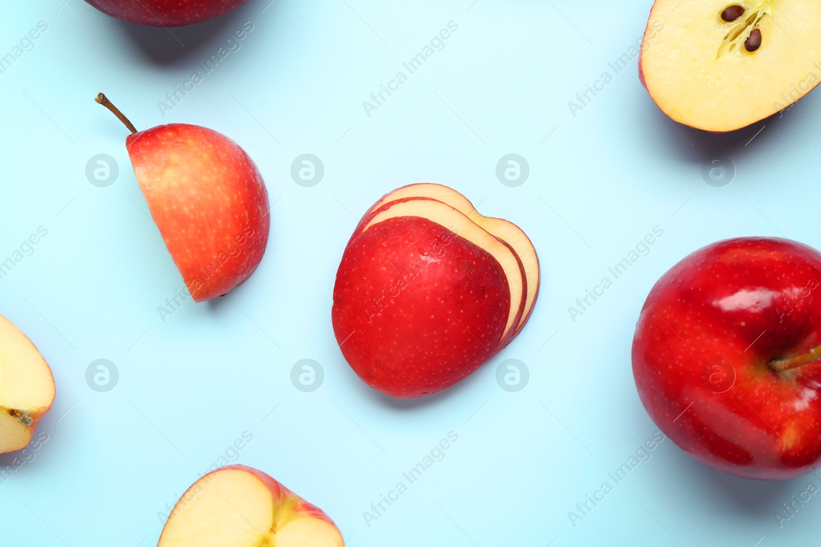 Photo of Fresh ripe red apples on light blue background, flat lay