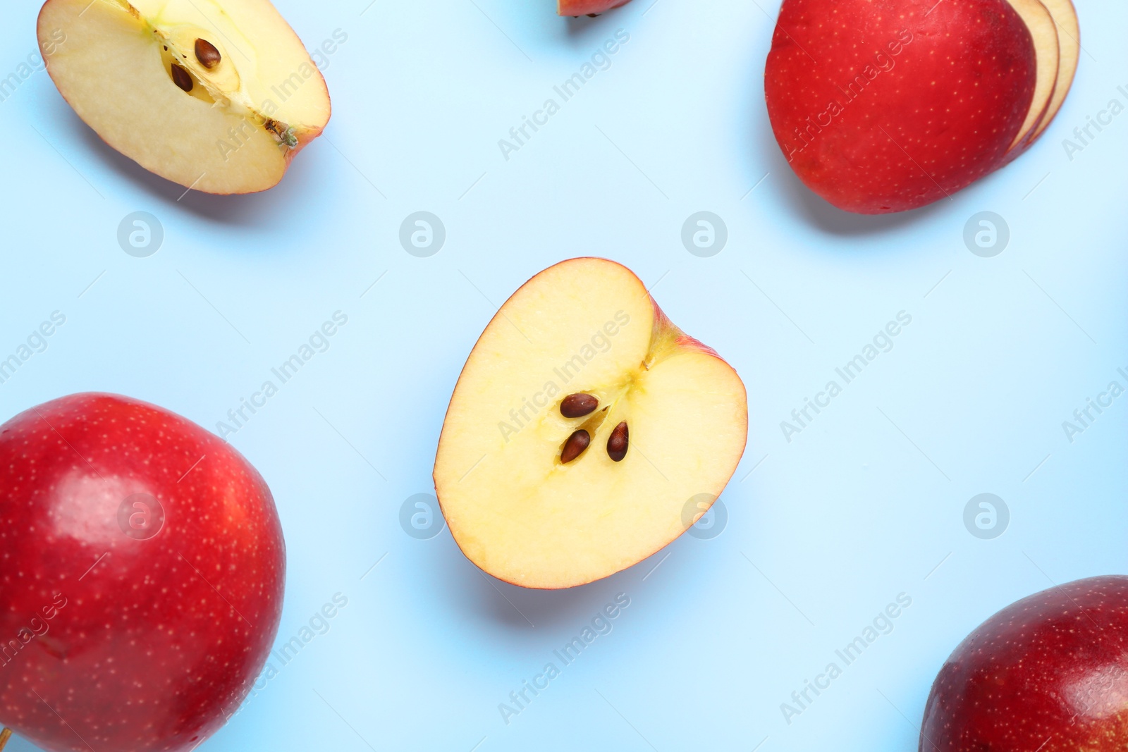 Photo of Fresh ripe red apples on light blue background, flat lay