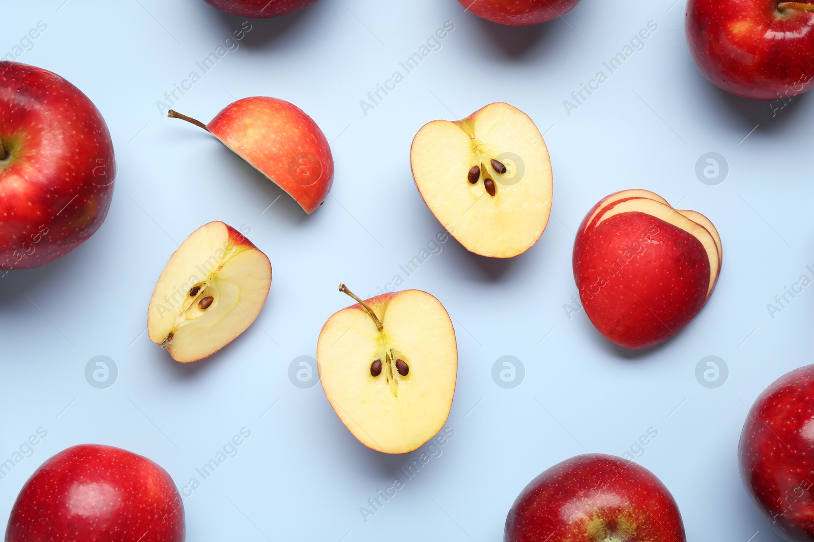 Photo of Fresh ripe red apples on light blue background, flat lay