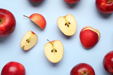 Fresh ripe red apples on light blue background, flat lay