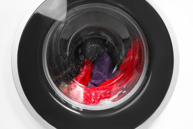 Photo of Washing machine with laundry as background, closeup