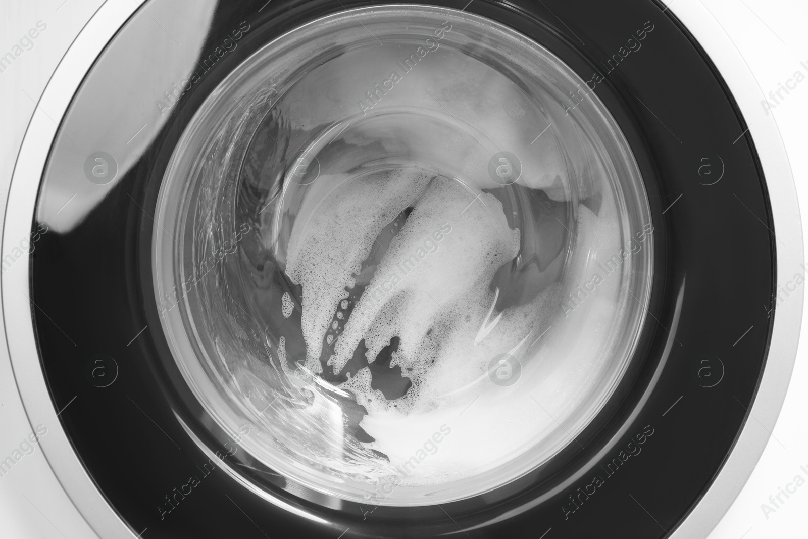 Photo of Washing machine with suds as background, closeup