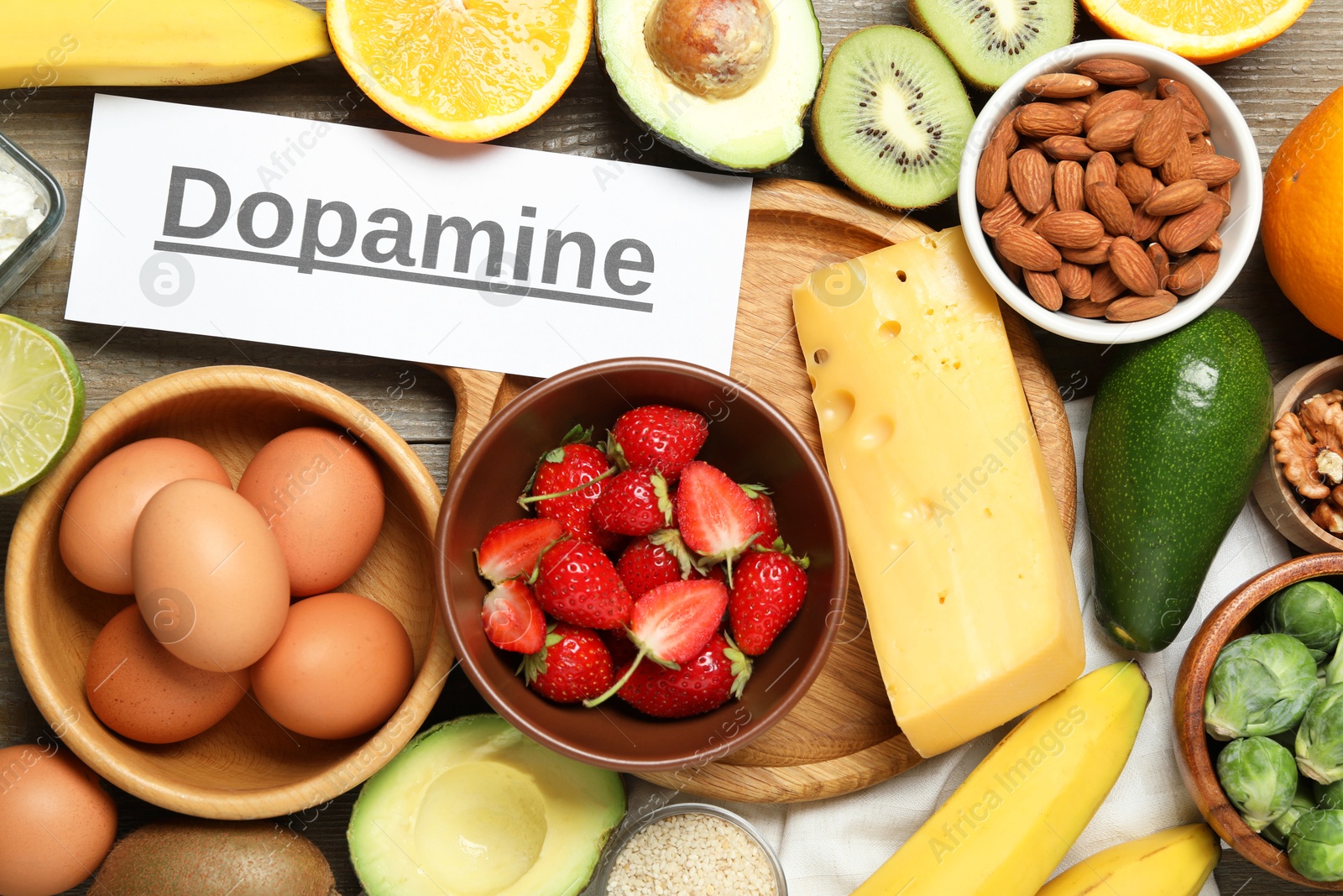 Photo of Word Dopamine and different products on wooden table, flat lay