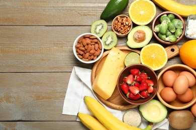 Photo of Different products rich in dopamine on wooden table, flat lay. Space for text