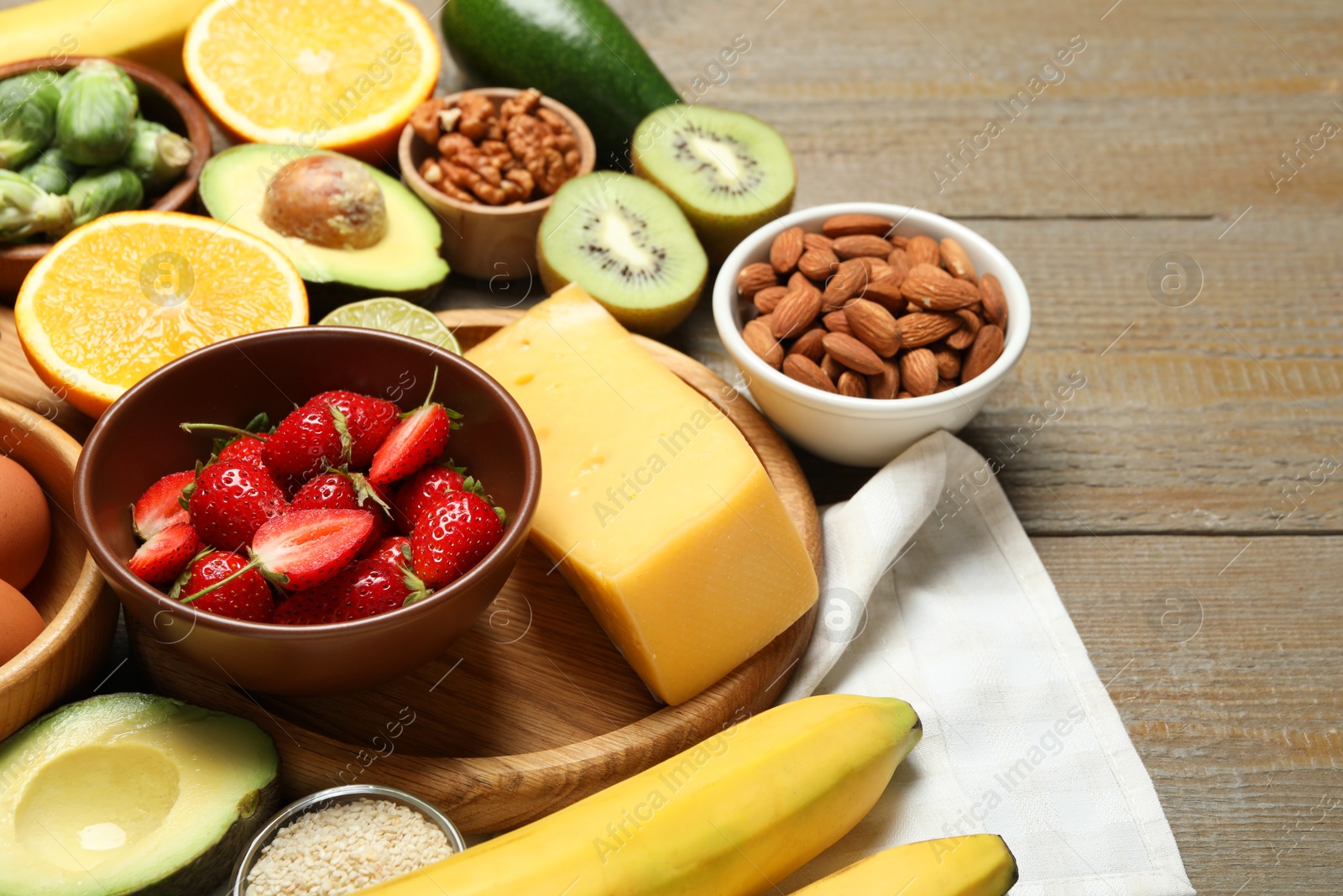 Photo of Different products rich in dopamine on wooden table