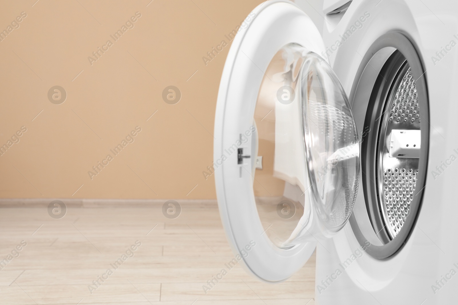 Photo of Washing machine with empty drum indoors, closeup. Space for text