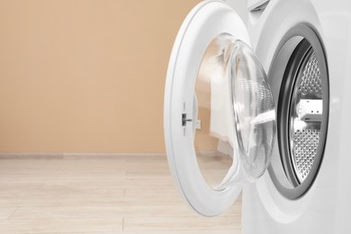 Photo of Washing machine with empty drum indoors, closeup. Space for text