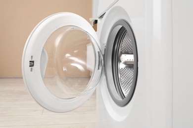 Photo of Washing machine with empty drum indoors, closeup