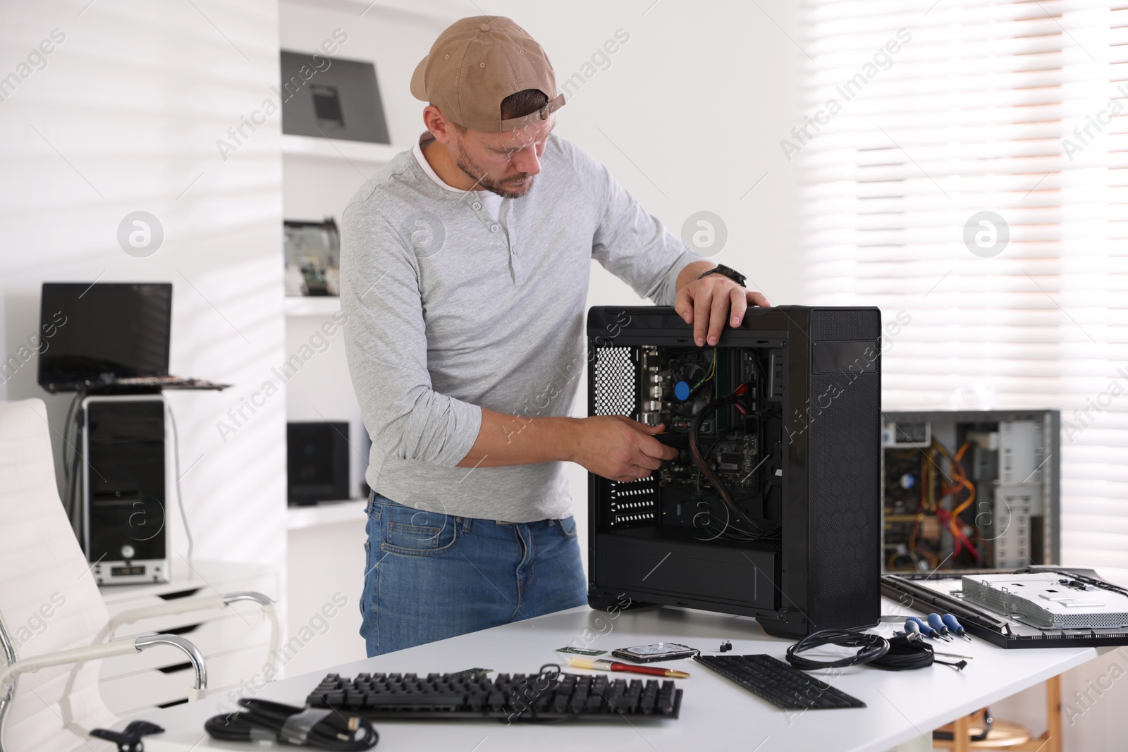 Photo of Man assembling new computer at white table