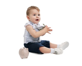 Photo of Little baby with money and piggybank on white background