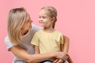 Photo of Cute little girl with her mom on pink background. Happy Mother's Day