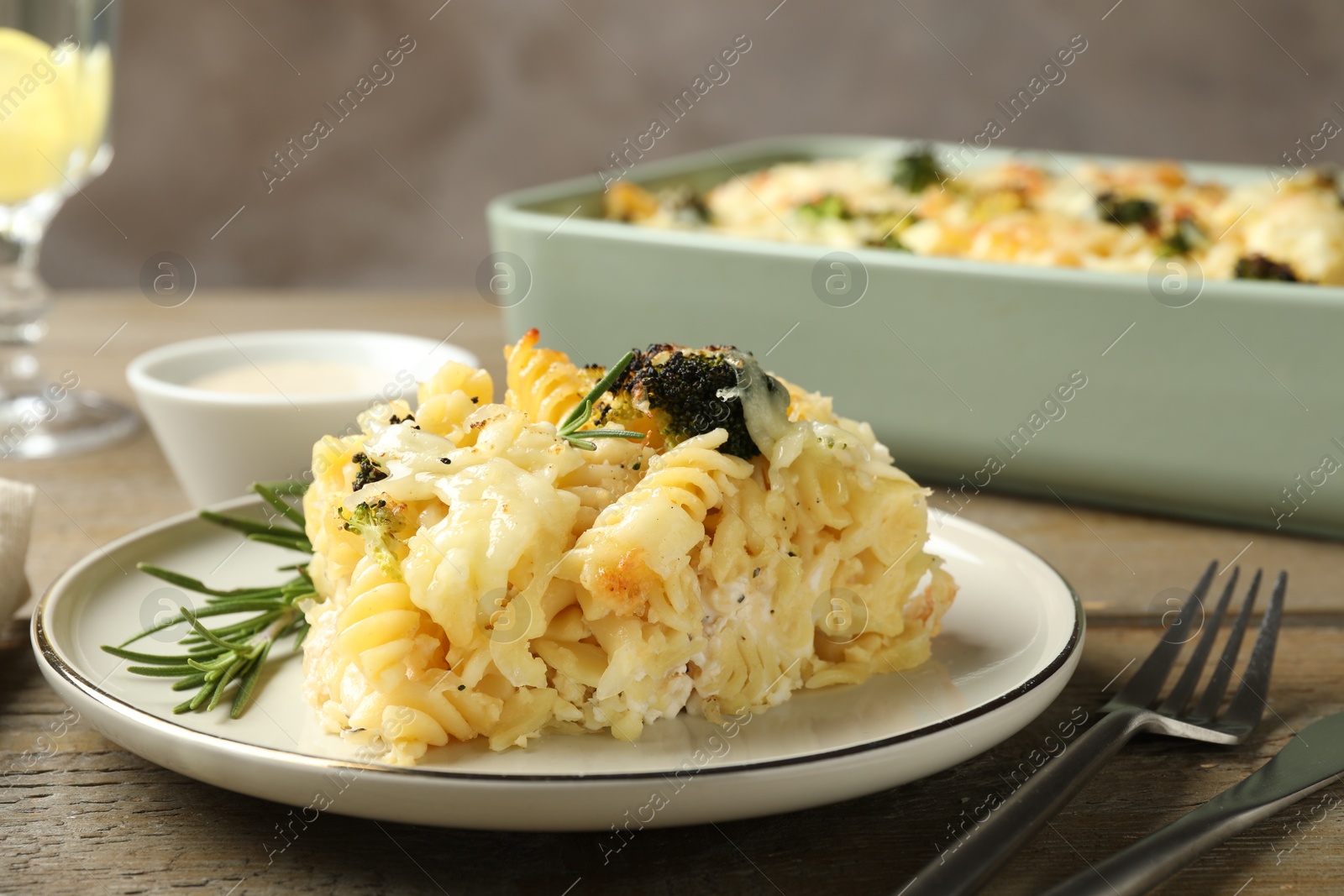 Photo of Tasty pasta casserole with cheese and broccoli served on wooden table, closeup