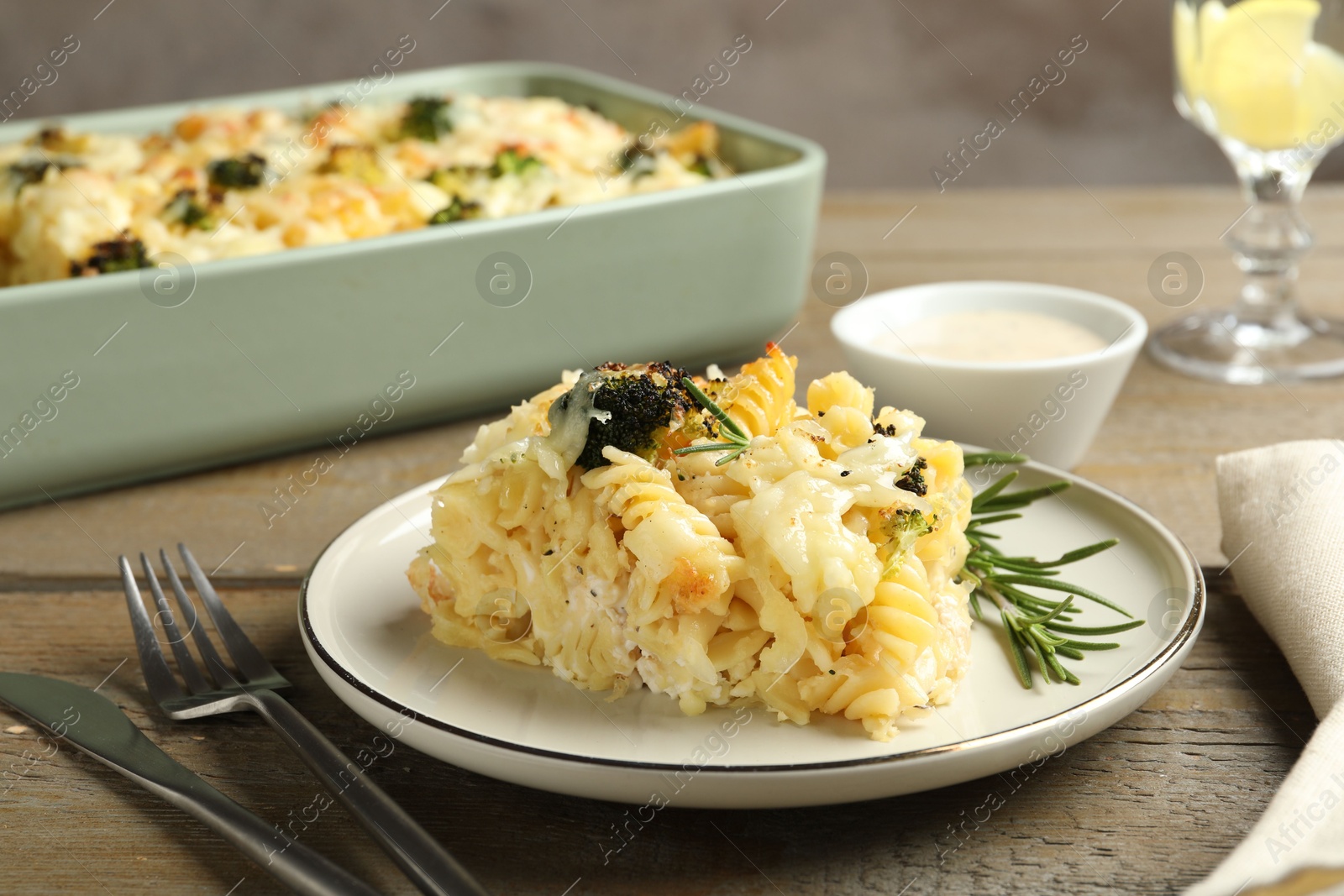 Photo of Tasty pasta casserole with cheese and broccoli served on wooden table, closeup