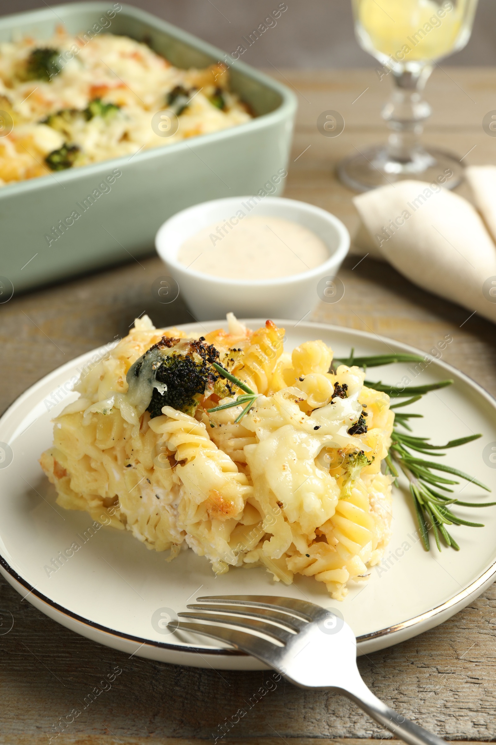 Photo of Tasty pasta casserole with cheese and broccoli served on wooden table, closeup