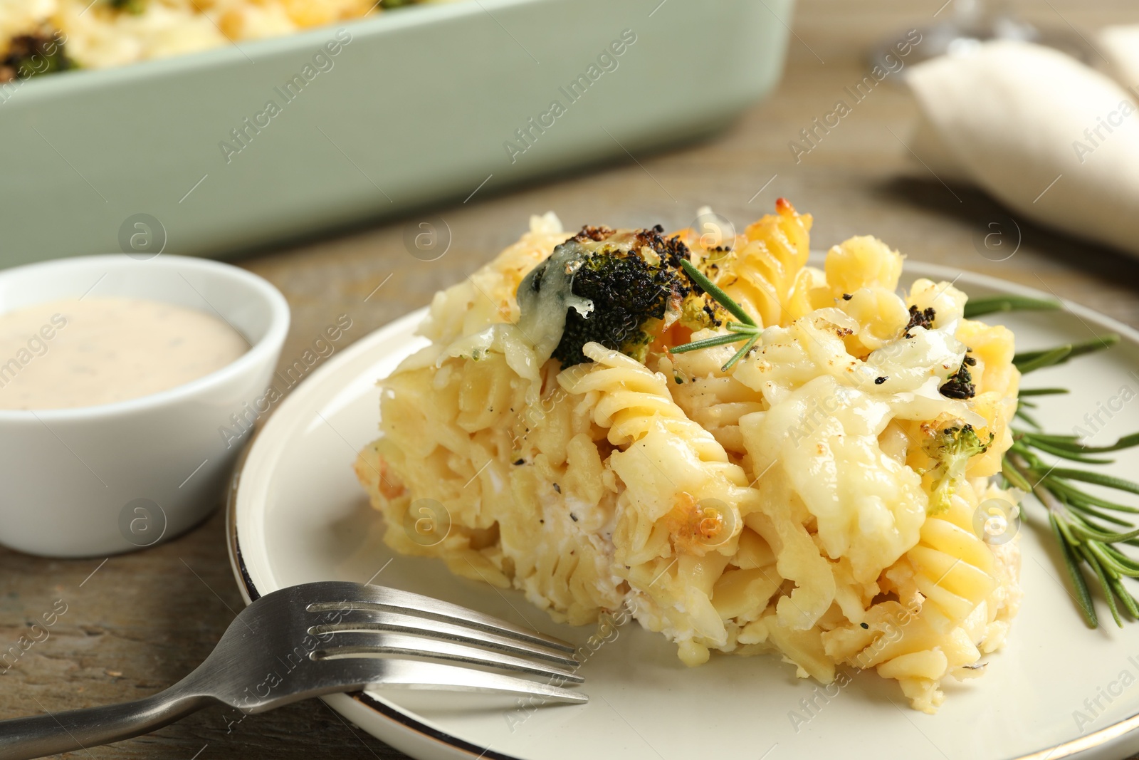 Photo of Tasty pasta casserole with cheese and broccoli served on wooden table, closeup