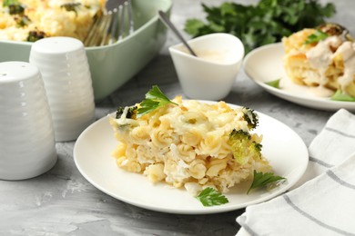 Photo of Tasty pasta casserole with cheese and broccoli served on grey table, closeup