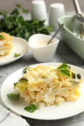 Photo of Tasty pasta casserole with cheese and broccoli served on grey table, closeup