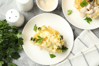 Photo of Tasty pasta casserole with cheese and broccoli served on grey table, flat lay