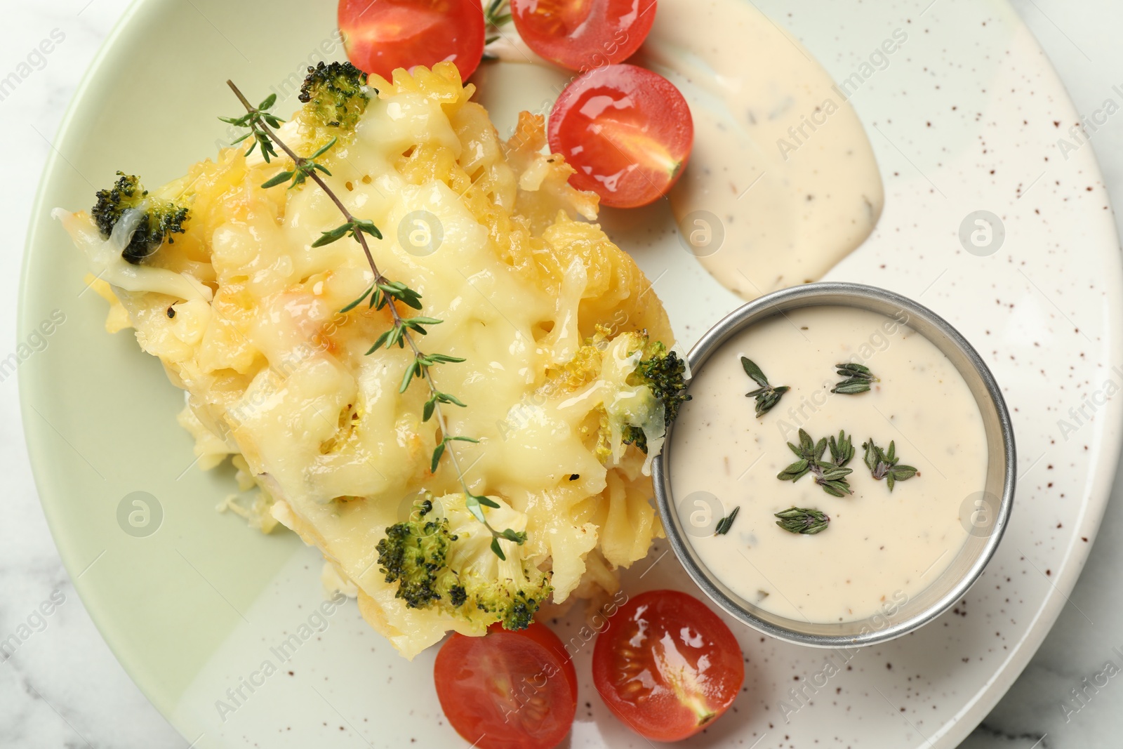 Photo of Tasty pasta casserole with cheese and broccoli served on white marble table, top view