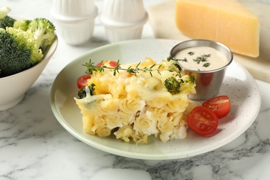 Photo of Tasty pasta casserole with cheese and broccoli served on white marble table, closeup