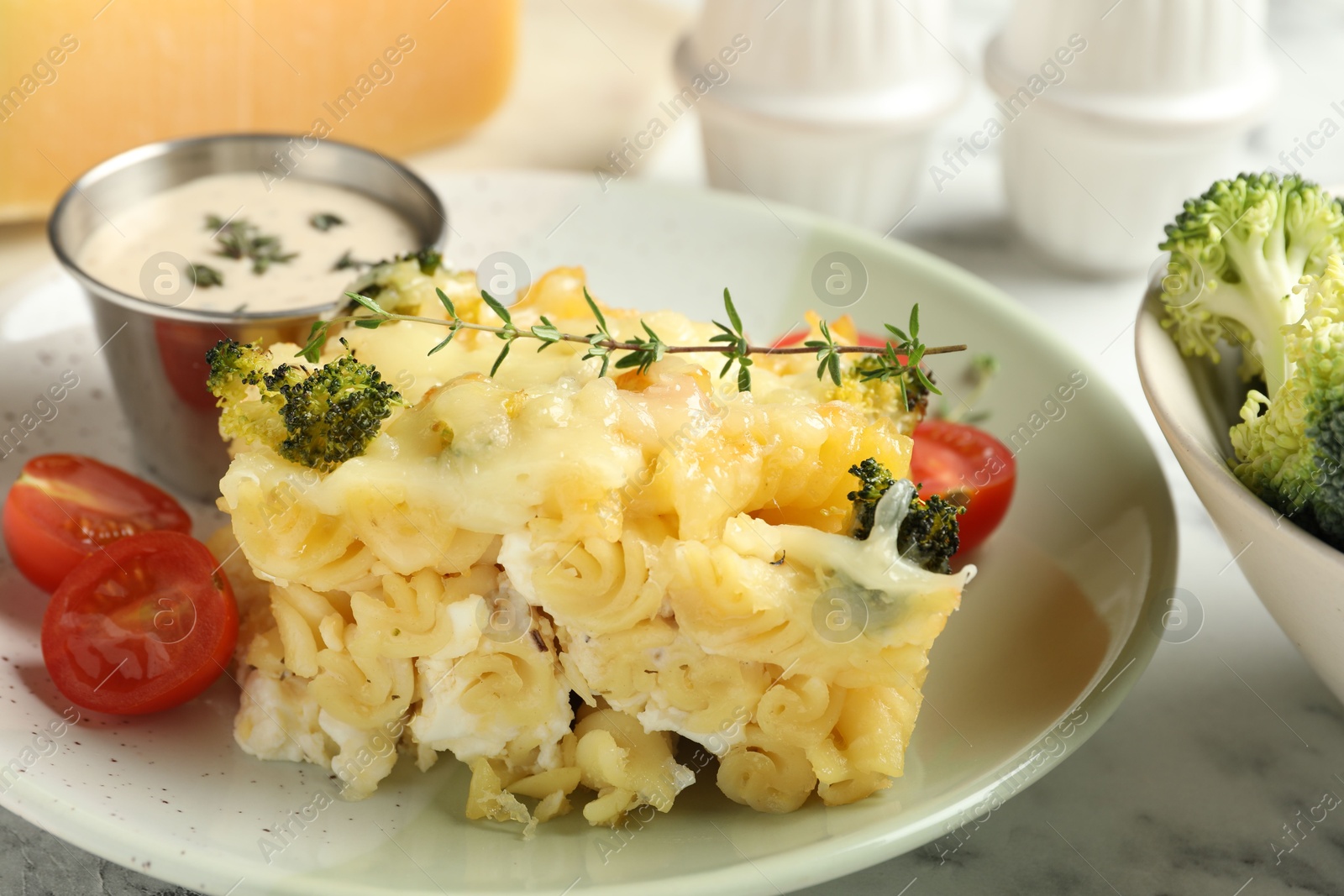 Photo of Tasty pasta casserole with cheese and broccoli served on white marble table, closeup