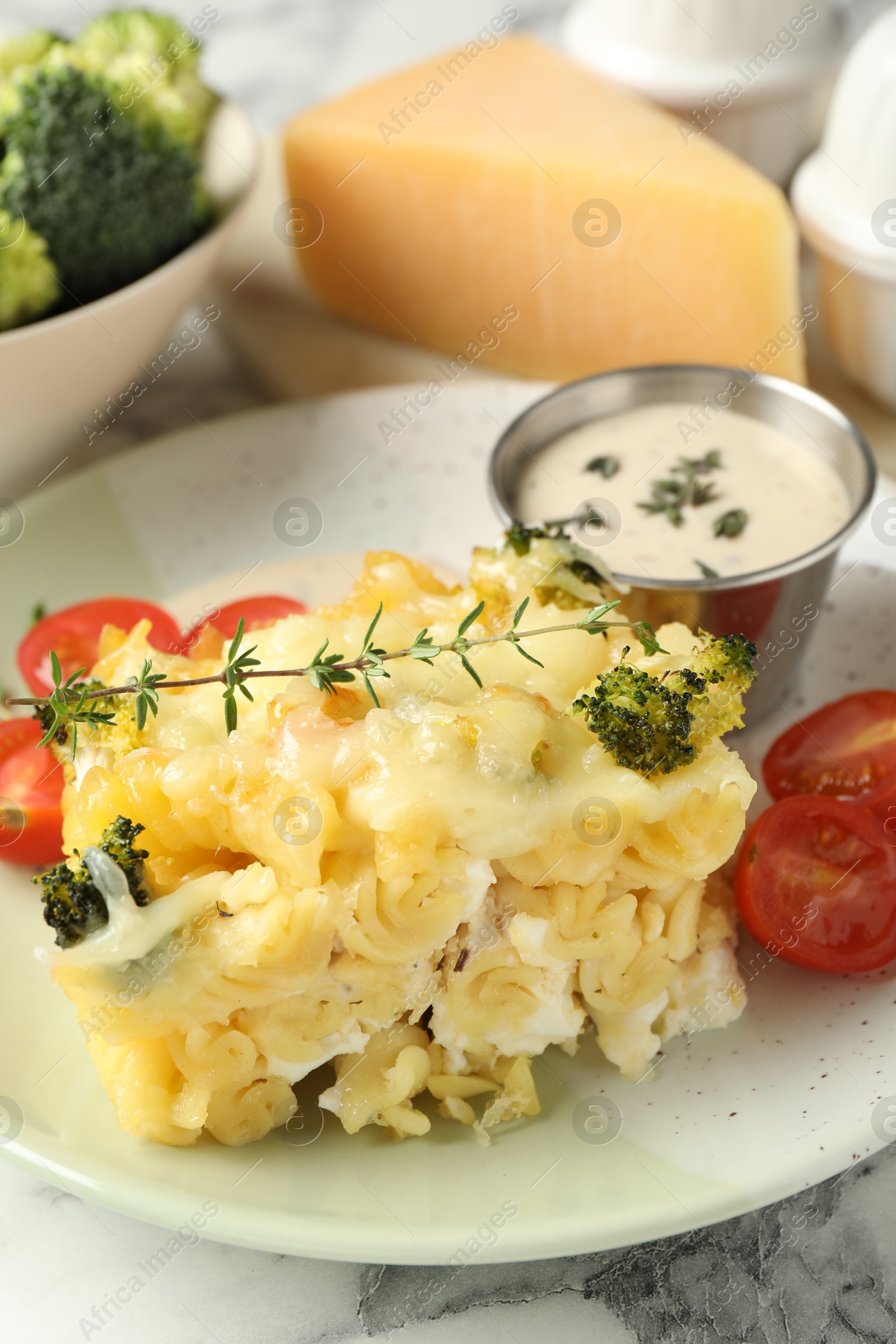 Photo of Tasty pasta casserole with cheese and broccoli served on white marble table, closeup