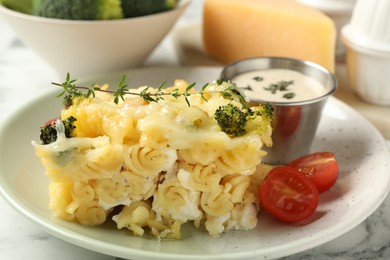 Photo of Tasty pasta casserole with cheese and broccoli served on white marble table, closeup