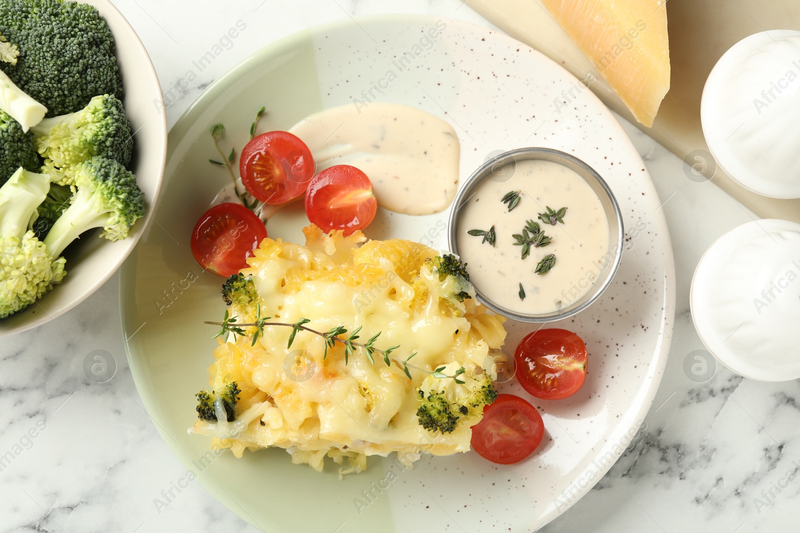 Photo of Tasty pasta casserole with cheese and broccoli served on white marble table, flat lay