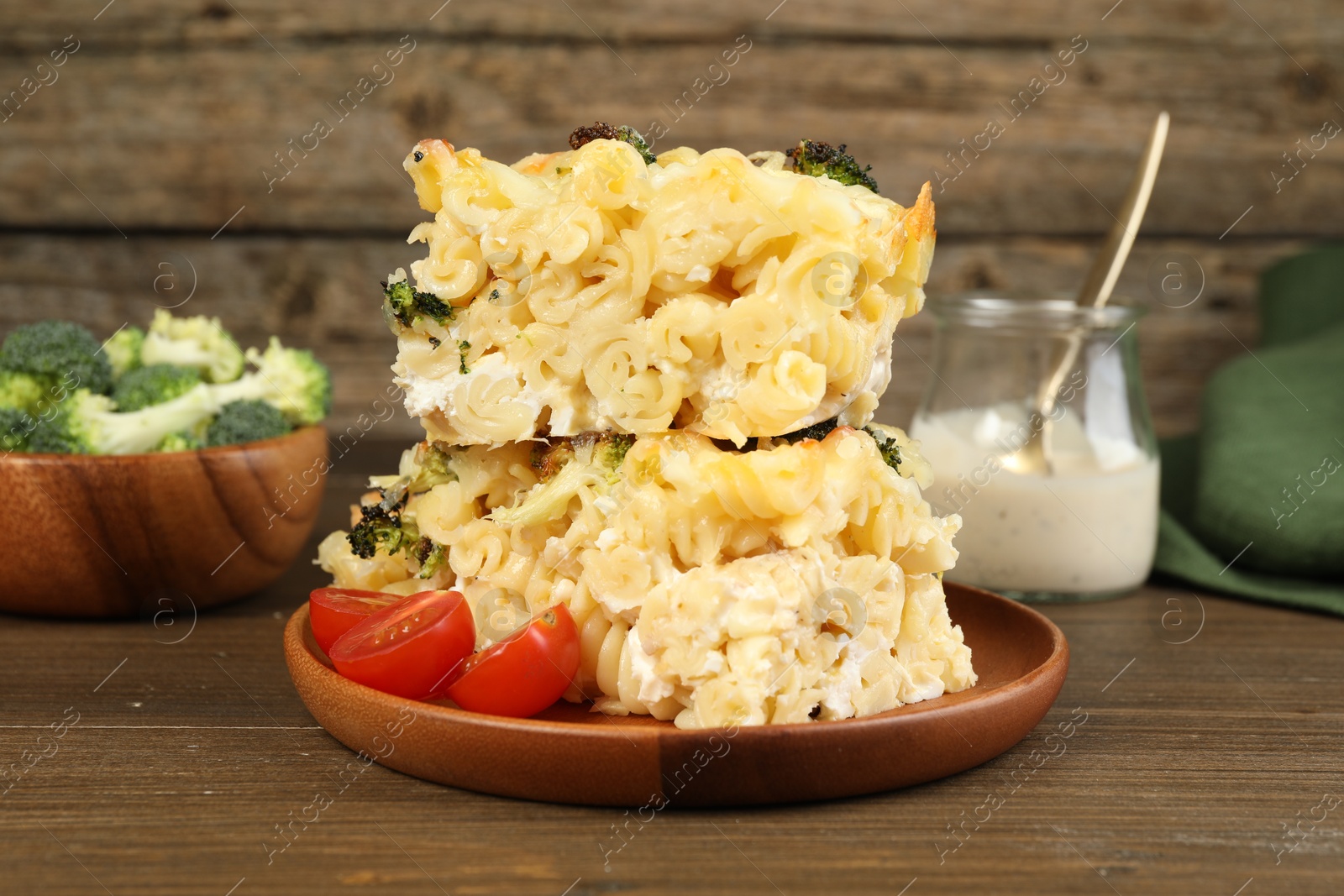 Photo of Tasty pasta casserole with cheese and broccoli served on wooden table, closeup